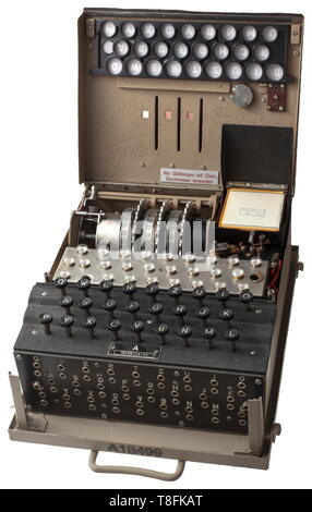 A German cypher machine 'Enigma' of the Wehrmacht with three rotors Iron housing, the folding lid with the lit keyboard, the connections for the external power supply and the alteration switch. Thereunder the three numeric encryption scrambling rotors with the numbers from 1 to 26, the lamp board with the 12 mm light bulbs (incomplete) and the battery compartment. In front of that the keyboard and the plugboard on the front side. No substitute plugs. In the removable vehicle storage box for the intelligence mounting frame, for example for the intelligence Kübelwagen Sd.Kfz., Editorial-Use-Only Stock Photo