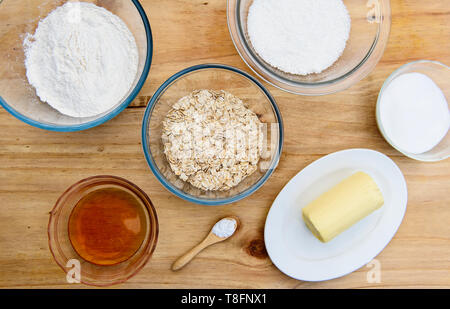 Ingredients for Anzac biscuits a traditional Australian cookie made with flour, butter, sugar, rolled oats, desiccated coconut and golden syrup Stock Photo