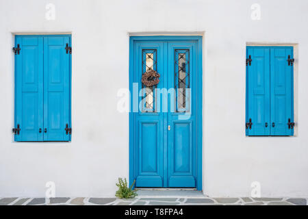 White house facade with traditional blue door on Paros island, Cyclades Stock Photo