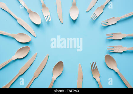 Disposable tableware from natural wooden materials, spoon, knife, and fork, eco-friendly. Space for text. Stock Photo