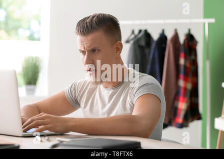 Troubled freelancer working on laptop at home Stock Photo