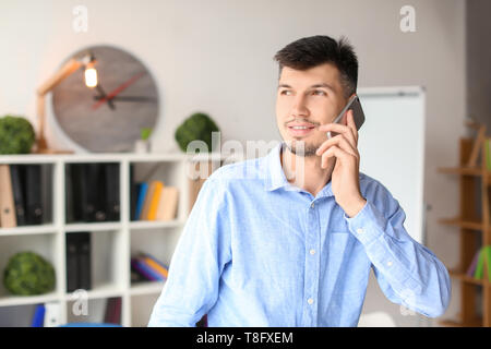 Businessman talking on phone in office Stock Photo