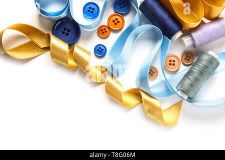 Different ribbons with threads and buttons on white background Stock Photo