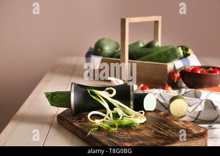 Fresh zucchini spaghetti with spiral grater on wooden table Stock Photo