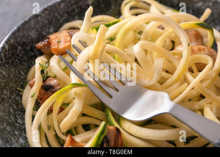Zucchini spaghetti with mushrooms in bowl, closeup Stock Photo