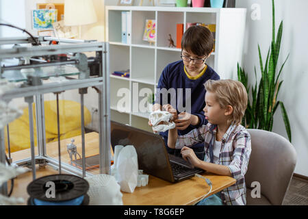Serious little boys sitting in equipped laboratory with laptop Stock Photo