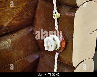Retro style light switch on a wall of logs Stock Photo