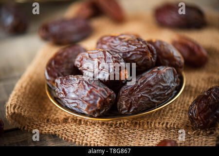 Ramadan food and drinks concept. Dates fruit in a bowl on wooden table background. Stock Photo