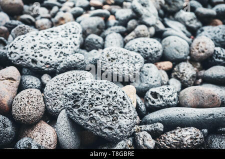 Natural background made of volcanic rocks and pebbles, selective focus, color toning applied. Stock Photo