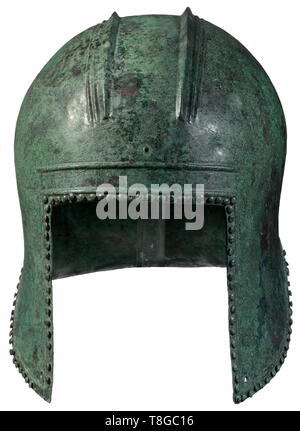 An Illyrian helmet, 6th century BC Bronze with bright green patina. High, slightly protruding skull with offset, doubly ridged plume holder and holes for fixation on the front as well as on the reverse side. Rectangular face opening under a reinforced profile. Deeply pulled down cheek-pieces and curved neck guard. Continuous profile border with lenticular ornamental rivets. Professional replacements and protections at the neck and the forehead. Height 23.5 cm, weight 1150 g. Provenance: South German private collection, family-owned since circa 19, Additional-Rights-Clearance-Info-Not-Available Stock Photo