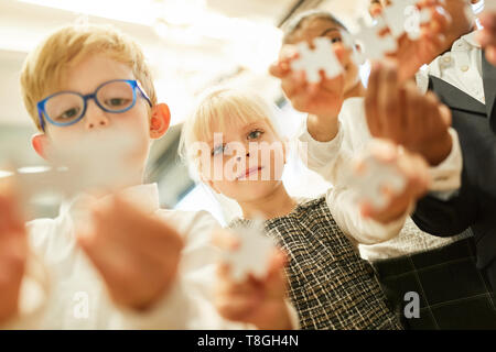 Group of kids in kindergarten or preschool playing puzzle Stock Photo