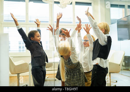 Children managers cheer as a business team at meeting Stock Photo