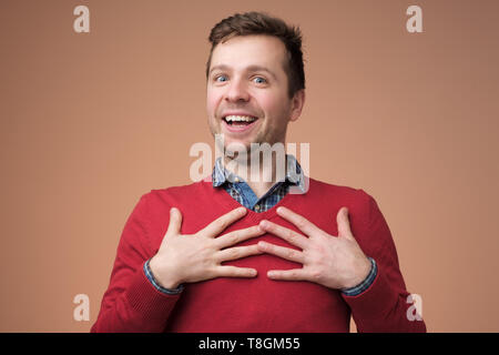 Young man being content to hear compliment Stock Photo