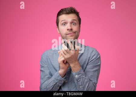 Young man in blue shirt using mobile phone. Stock Photo