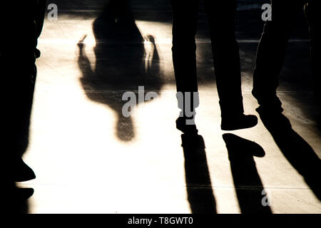 Shadow silhouettes of people walking in sepia black and white Stock Photo