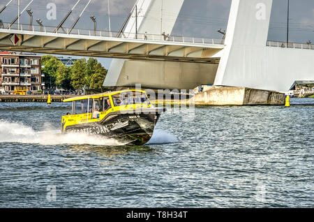 Rotterdam, The Netherlands, August 13, 2018: black and yellow water taxi on Nieuwe Maas river passing under Erasmus bridge Stock Photo