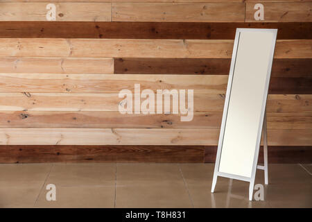 Large mirror near wooden wall Stock Photo