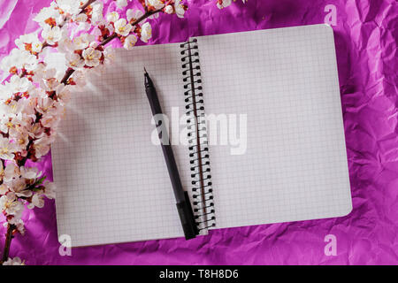 Open blank notebook, pen and cherry blossoming branch on bright background. Concepts of romance and love Stock Photo