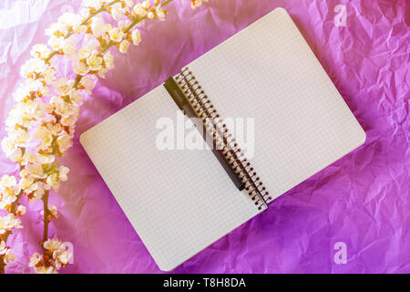 Open blank notebook, pen and cherry blossoming branch on bright background. Concepts of romance and love Stock Photo