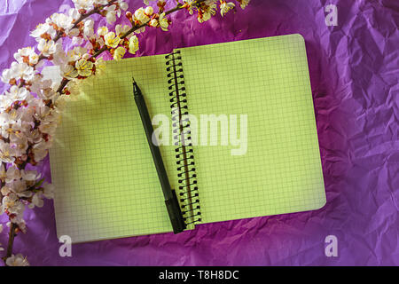 Open blank notebook, pen and cherry blossoming branch on bright background. Concepts of romance and love Stock Photo