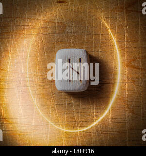 Hagalaz. Handmade scandinavian wooden runes on a wooden vintage background in a circle of light. Concept of fortune telling and prediction of the Stock Photo