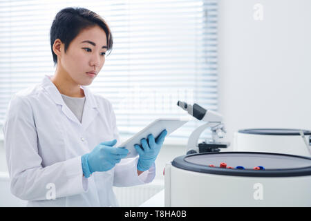 Modern researcher viewing results on tablet Stock Photo