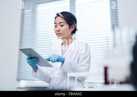 Busy Asian laboratory specialist working with data Stock Photo