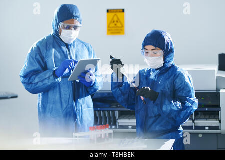 Multiethnic clinical scientists working with blood samples Stock Photo