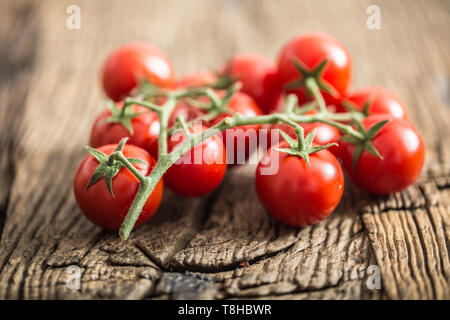 Fresh bunch of ripe tomatoes on old oak table. Stock Photo