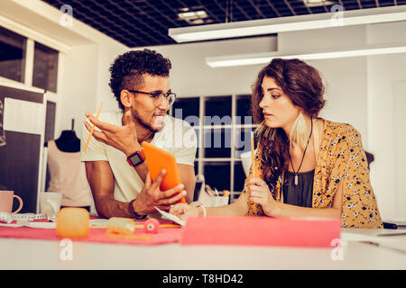 Young coworkers discussing their ideas in a studio. Stock Photo