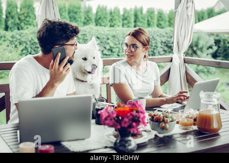 Concentrated serious woman talking to her handsome dark-haired husband Stock Photo
