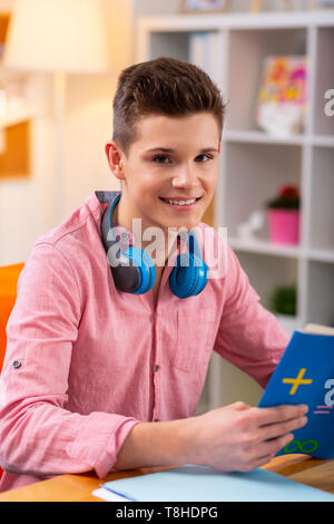 Handsome teenager feeling good after reading interesting book Stock Photo