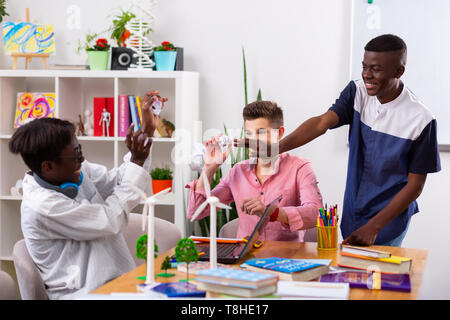 Teenagers having fun while throwing papers after studying Stock Photo