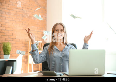 Happy businesswoman with lot of money in office Stock Photo