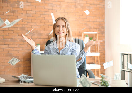 Happy businesswoman with lot of money in office Stock Photo