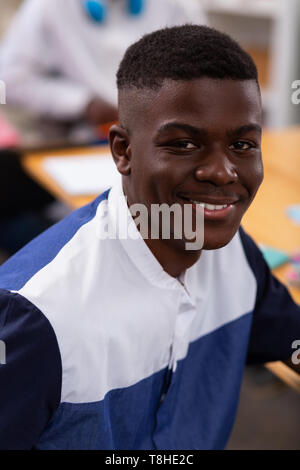 Dark-skinned short-haired teenager smiling while feeling satisfied Stock Photo