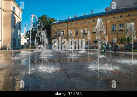 kids playing at city square near fountain. summer time Stock Photo