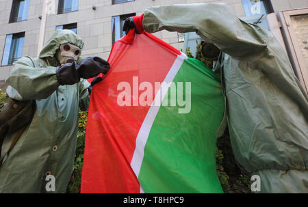 May 13, 2019 - Kyiv, Ukraine - Emigrant activists of the Association of Indigenous Peoples of Russia wearing hazmat suits hold Tatarstan flag as they picket the German Embassy with the demand to audit Russian oil companies that had exported crude oil to EU countries and, activists believe, it had led to an environmental catastrophe in Tatarstan, in Kyiv, Ukraine, May 13, 2019. Russiaâ€™s Investigative Committee identified six suspects in the contamination of millions of barrels of crude, which shut down pipeline shipments to some European countries. In March and April this year, some of the su Stock Photo