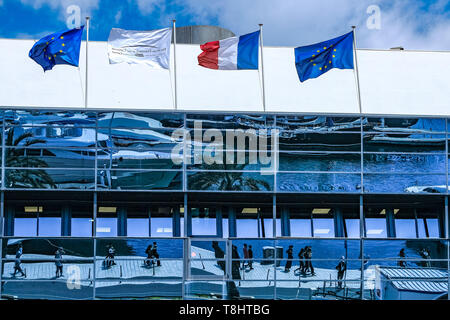 Cannes, France. 13th May 2019. Rows of luxury super yachts are reflected in the windows of the Palais des Festivals on Monday 13 May 2019 at the 72nd Festival de Cannes, Palais des Festivals, Cannes. Yachts are docked in the harbour and prepared as event and meeting spaces for celebrities and film companies during the festival . Credit: Julie Edwards/Alamy Live News Stock Photo