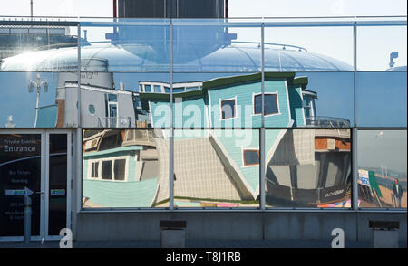 Brighton, UK. 14th May, 2019. Brighton's newest tourist attraction the Upside Down House is reflected in the windows of the nearby British Airways i360 observation tower on the seafront near the West Pier on a beautiful sunny morning with temperatures reaching into the twenties in some parts of Britain today. The Upside Down House is due to open to the public this coming weekend . Credit: Simon Dack/Alamy Live News Stock Photo