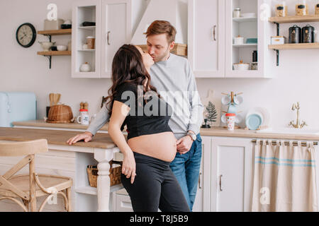 Portrait of a smiling couple kissing in the kitchen Stock Photo