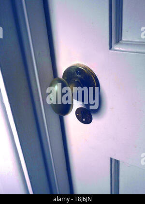 Close up of a brass door handle on a closed old wooden door. Stock Photo