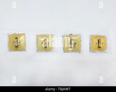 Vintage switches and light switches on the wall. Four subjects electricians in the room. Stock Photo