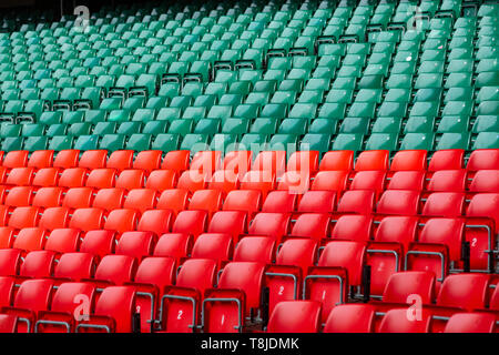 Red and green plastic seats in an empty, large sports stadium Stock Photo