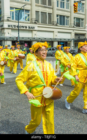 Falun Dafa, also known as Falun Gong, practitioners march in parade through streets of downtown Vancouver on Mother's Day 2019. Stock Photo