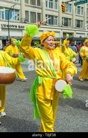 Falun Dafa, also known as Falun Gong, practitioners march in parade through streets of downtown Vancouver on Mother's Day 2019. Stock Photo