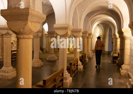Worcester Cathedral crypt - a visitor waking in the interior of the 11th century Norman crypt, Worcester Cathedral, Worcestershire England UK Stock Photo