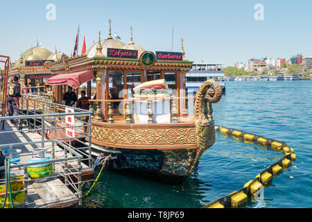 Istanbul, Turkey - April 25, 2017: Traditional fast food bobbing boat serving fish sandwiches at Eminonu with chefs preparing meals Stock Photo