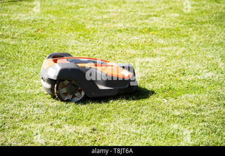 Husqvarna Automower robot lawnmower cutting a lawn, UK Stock Photo