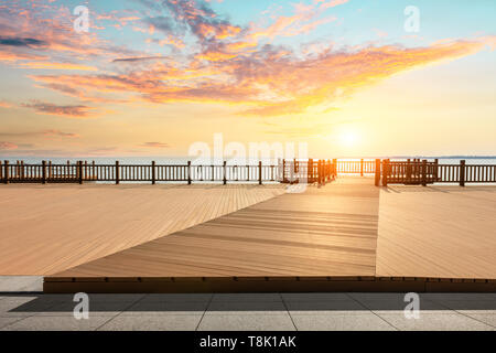 Lakeside wood floor platform and sky clouds at sunset Stock Photo